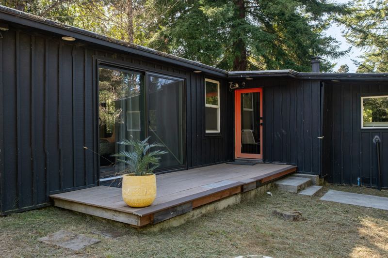 Wood deck and red door of the black cabin